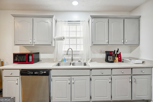 kitchen featuring gray cabinetry, a textured ceiling, sink, and stainless steel dishwasher