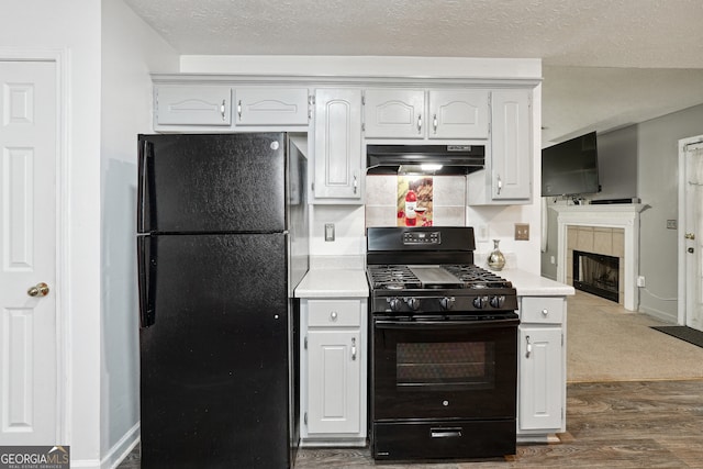 kitchen with a textured ceiling, dark wood-type flooring, white cabinetry, a fireplace, and black appliances