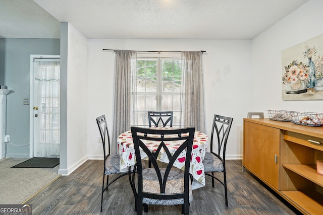 dining space featuring a textured ceiling and dark wood-type flooring