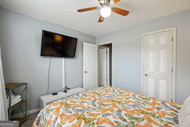 bedroom featuring ceiling fan, a textured ceiling, and carpet