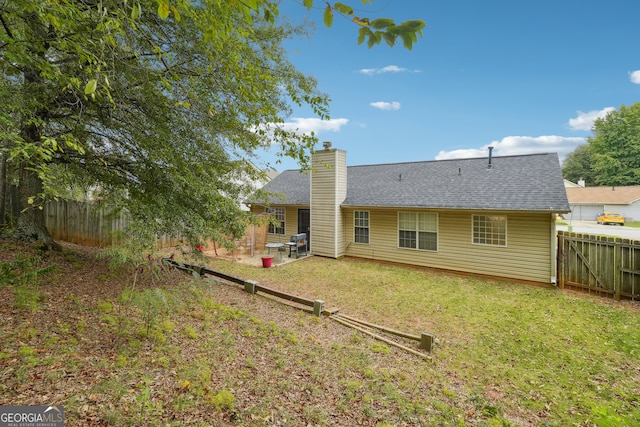 back of property with a lawn and a patio area