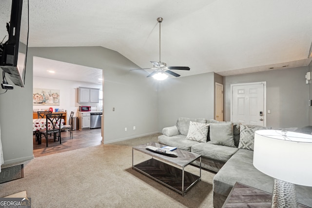 carpeted living room with a textured ceiling, lofted ceiling, and ceiling fan