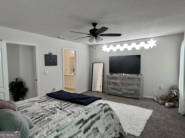 carpeted bedroom featuring a textured ceiling, ensuite bath, and ceiling fan