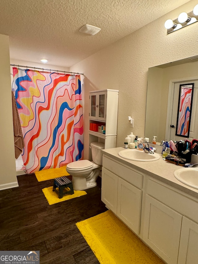 bathroom featuring vanity, toilet, a textured ceiling, hardwood / wood-style floors, and a shower with shower curtain