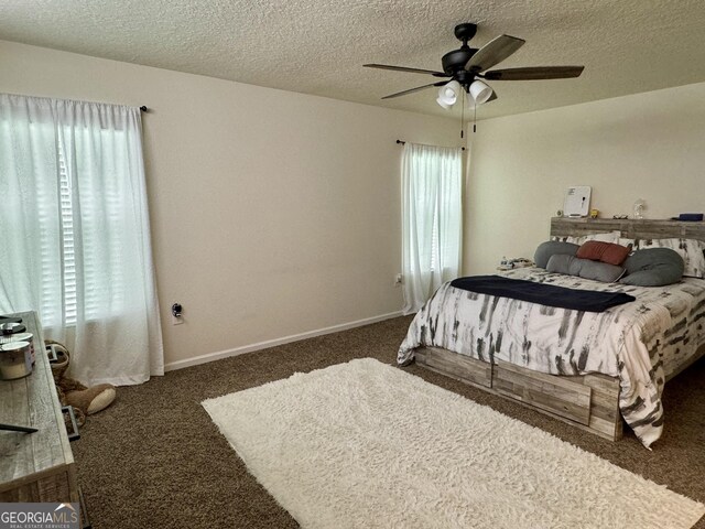 bedroom with dark colored carpet, ceiling fan, and a textured ceiling