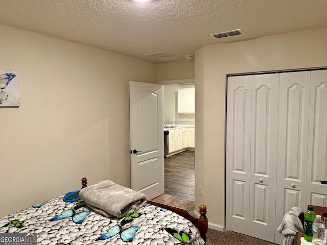 bedroom featuring a closet, dark wood-type flooring, and a textured ceiling