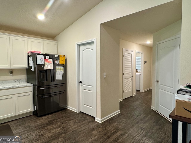 kitchen with lofted ceiling, white cabinetry, black refrigerator with ice dispenser, and dark hardwood / wood-style flooring