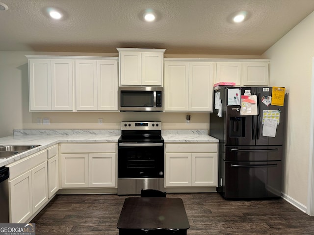 kitchen featuring white cabinets, appliances with stainless steel finishes, and dark hardwood / wood-style floors