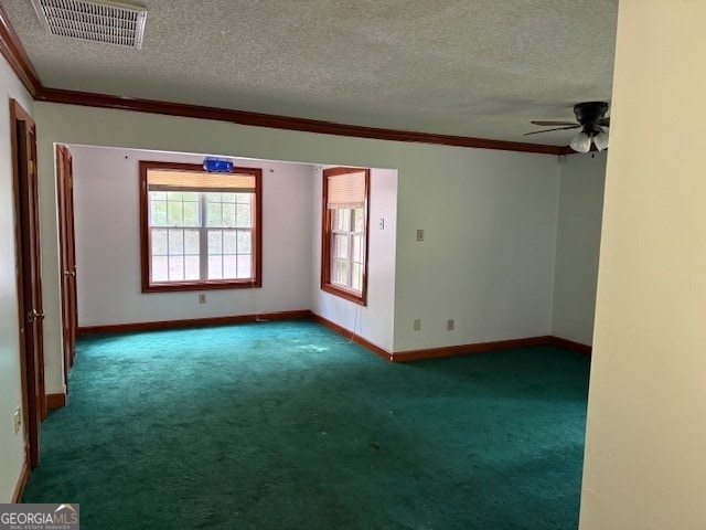 carpeted spare room with ornamental molding, a textured ceiling, and ceiling fan