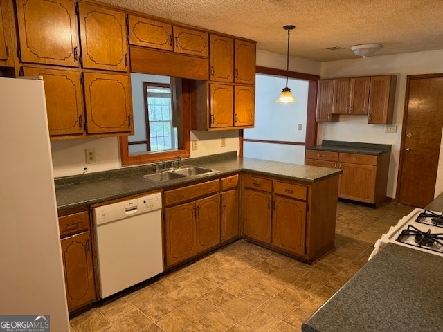 kitchen with a textured ceiling, hanging light fixtures, sink, and white appliances