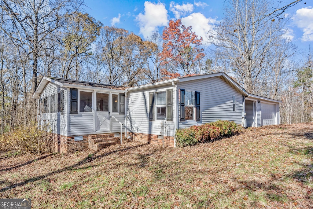 853 Adams Duncan Rd, Hull, GA 30646 - view of front of house featuring a front yard, a garage, and a sunroom