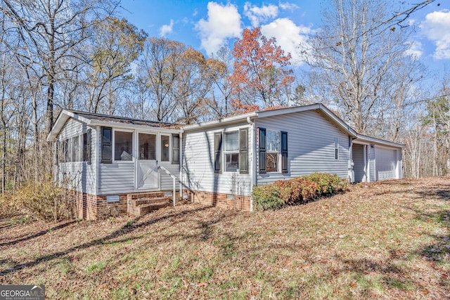 view of front of house featuring a front yard, a garage, and a sunroom