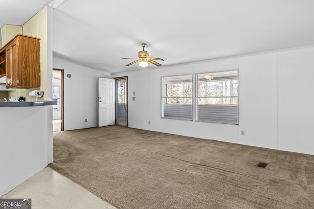 unfurnished living room featuring ceiling fan and light carpet