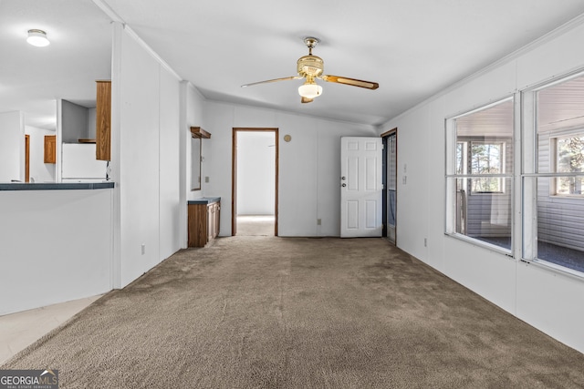 empty room featuring carpet flooring, ceiling fan, lofted ceiling, and crown molding