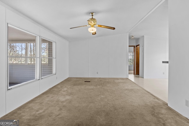 carpeted empty room with ceiling fan, plenty of natural light, and lofted ceiling