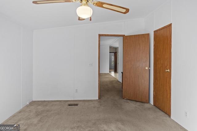 unfurnished room with lofted ceiling, light colored carpet, ceiling fan, and crown molding