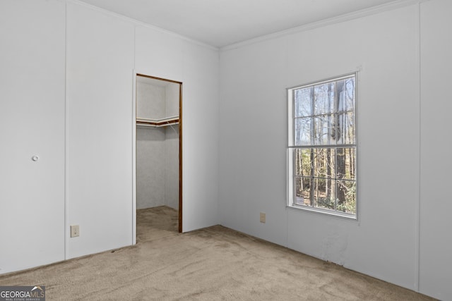 unfurnished bedroom featuring a walk in closet, light carpet, and multiple windows