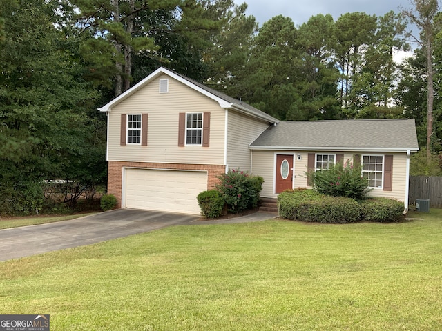 tri-level home with a garage, central AC, and a front lawn