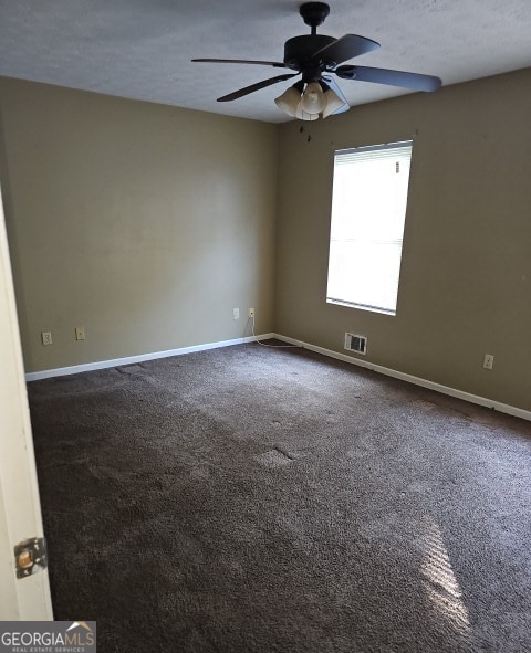 carpeted empty room with ceiling fan and a textured ceiling