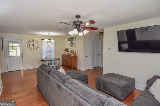 living room with a textured ceiling, ceiling fan with notable chandelier, and hardwood / wood-style floors