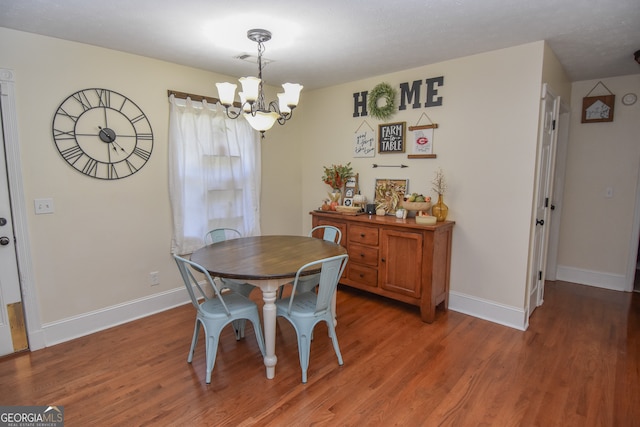 dining space with a chandelier and hardwood / wood-style floors