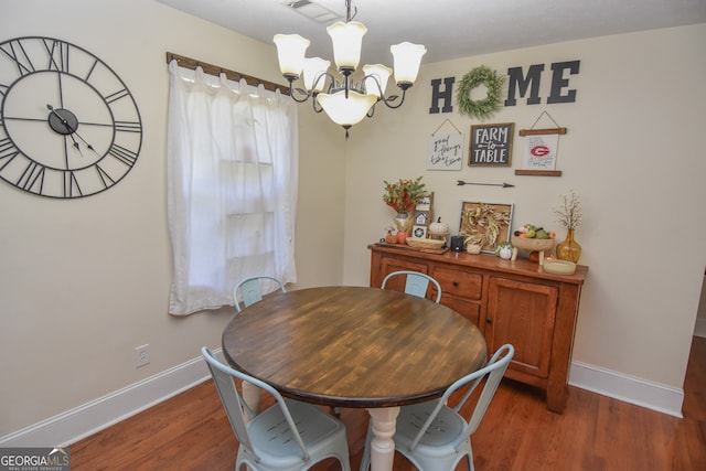 dining space featuring an inviting chandelier and dark hardwood / wood-style floors