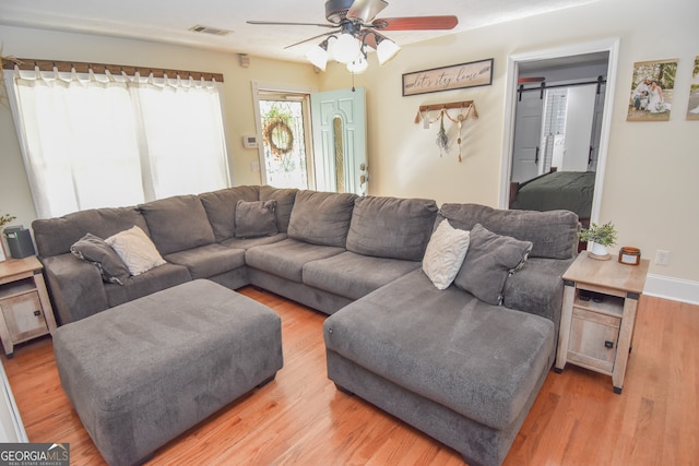 living room featuring light hardwood / wood-style flooring and ceiling fan