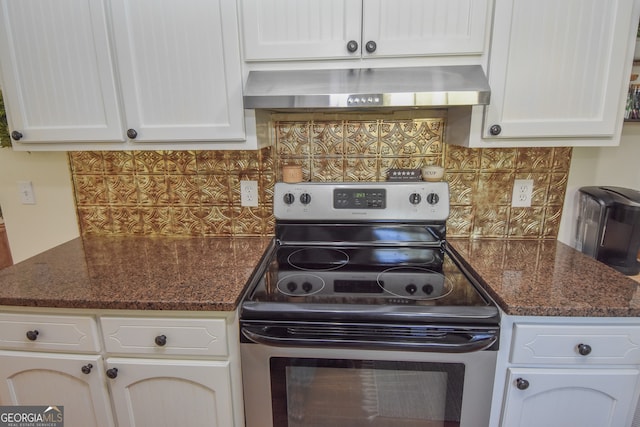 kitchen featuring stainless steel range with electric cooktop, backsplash, white cabinetry, and wall chimney range hood