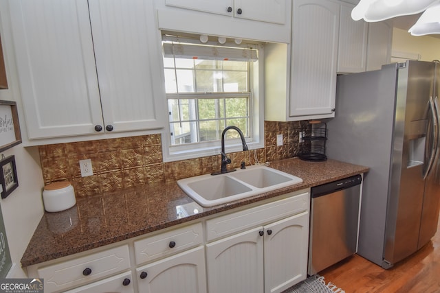 kitchen featuring sink, white cabinetry, stainless steel appliances, light wood-type flooring, and decorative backsplash