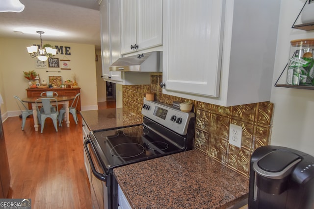 kitchen with white cabinetry, stainless steel range with electric stovetop, light wood-type flooring, an inviting chandelier, and decorative light fixtures