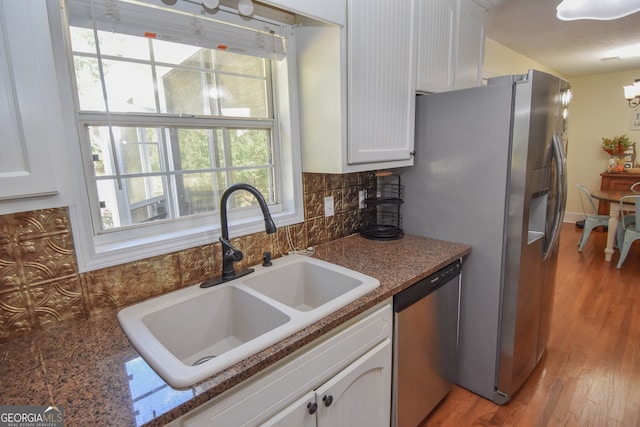 kitchen featuring light hardwood / wood-style floors, white cabinetry, tasteful backsplash, stainless steel appliances, and sink