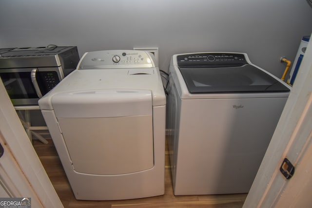 laundry area featuring wood-type flooring and washing machine and dryer