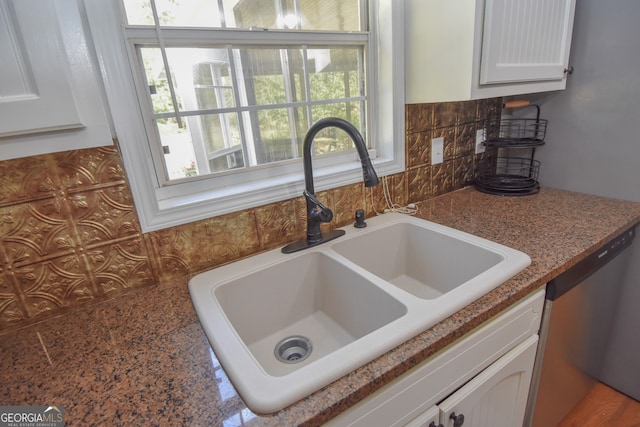 room details featuring stainless steel dishwasher, white cabinetry, sink, and tasteful backsplash