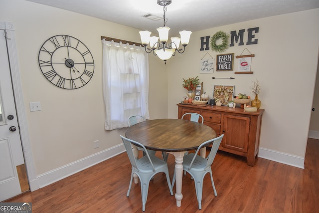 dining area featuring a notable chandelier and hardwood / wood-style flooring