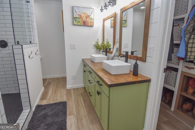 bathroom featuring hardwood / wood-style floors, a shower, and vanity