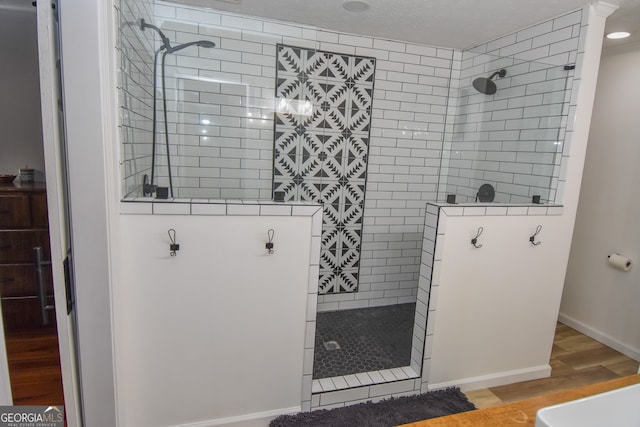 bathroom featuring hardwood / wood-style floors and tiled shower