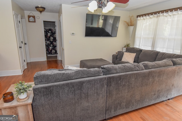 living room with hardwood / wood-style floors and ceiling fan