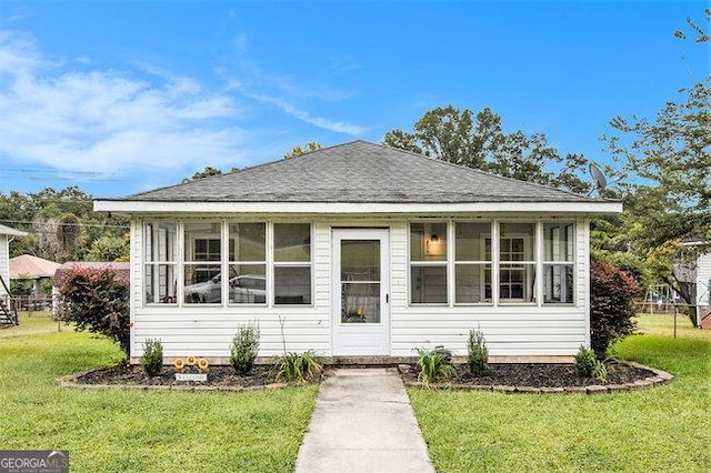 bungalow with a sunroom and a front yard