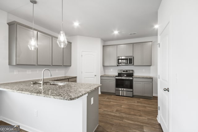 kitchen with appliances with stainless steel finishes, hanging light fixtures, sink, and gray cabinetry