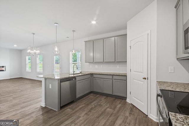 kitchen featuring light stone counters, pendant lighting, sink, dishwasher, and dark hardwood / wood-style floors