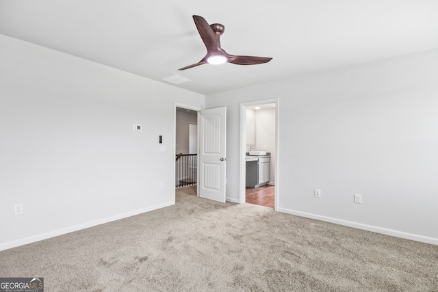 empty room with ceiling fan and light carpet