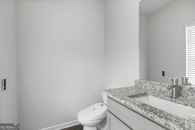 bathroom featuring hardwood / wood-style flooring, vanity, and toilet