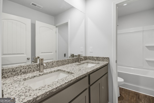 full bathroom with bathing tub / shower combination, vanity, toilet, and hardwood / wood-style flooring