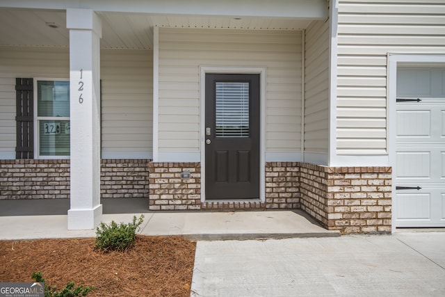 view of exterior entry with covered porch