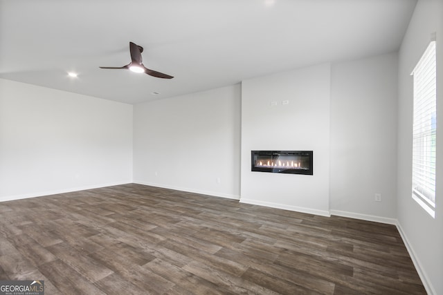 unfurnished living room with ceiling fan and dark hardwood / wood-style floors