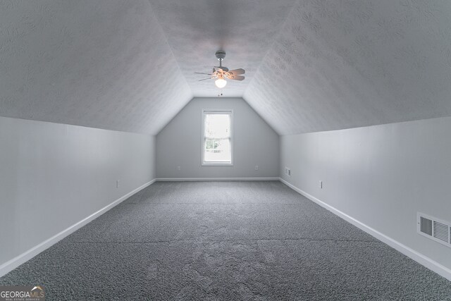 bonus room with a textured ceiling, lofted ceiling, ceiling fan, and carpet floors