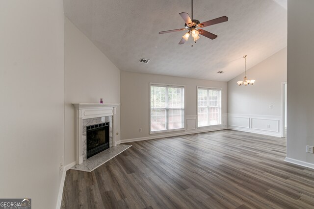 unfurnished living room featuring a textured ceiling, ceiling fan with notable chandelier, a premium fireplace, high vaulted ceiling, and dark hardwood / wood-style flooring