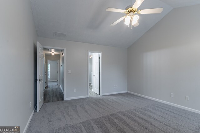 unfurnished bedroom with lofted ceiling, ceiling fan, carpet floors, and ensuite bath