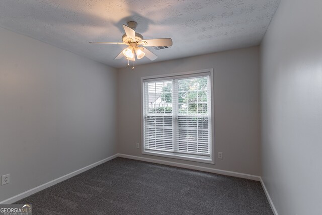 carpeted spare room featuring ceiling fan and a textured ceiling