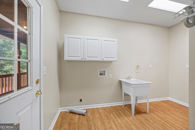 laundry room with cabinets, light hardwood / wood-style floors, electric dryer hookup, and hookup for a washing machine